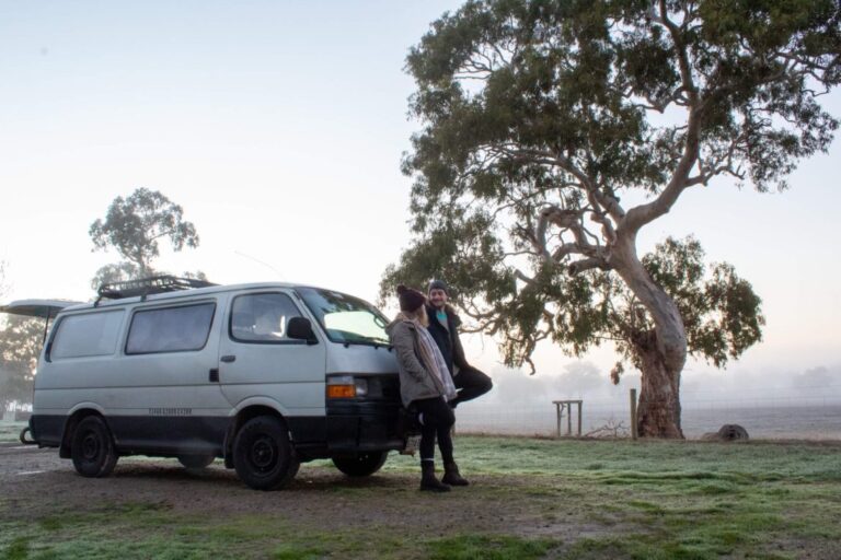 a couple standing in front of their campervan