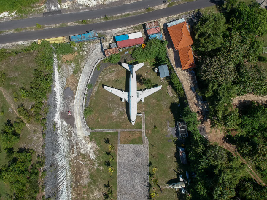 An abandoned airplane sits in a field.