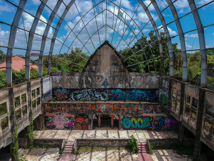 An old building in the abandoned theme park, covered in graffiti.