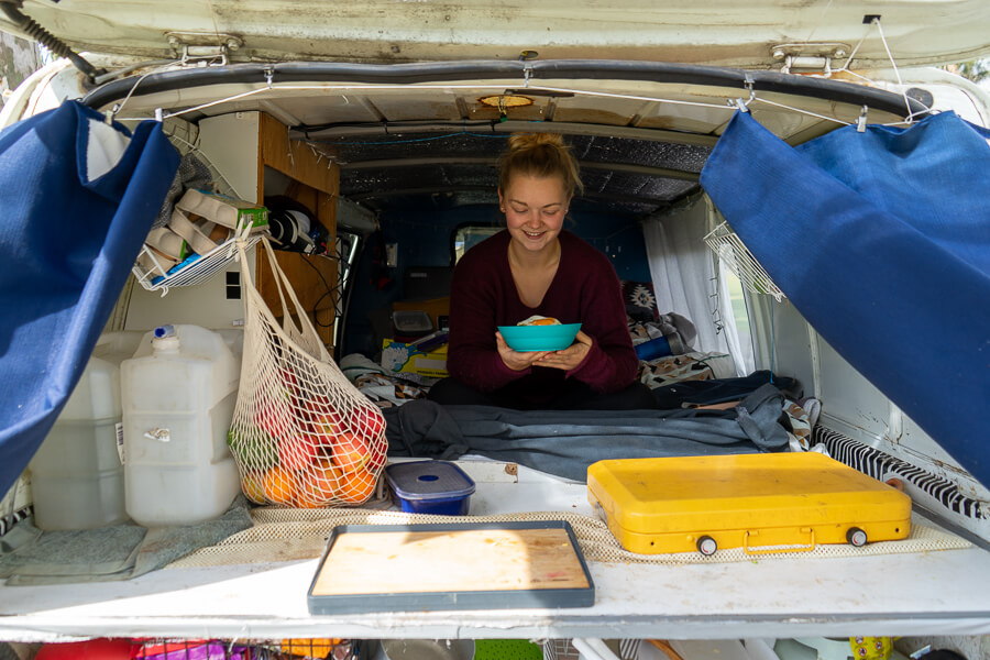 Gemma sitting and eating in a campervan