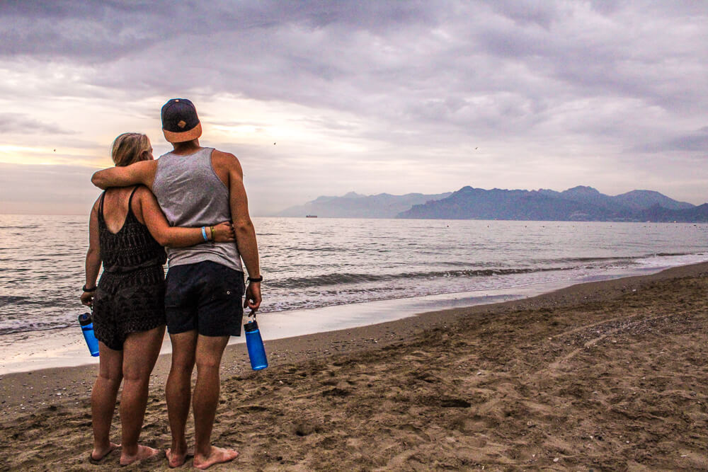 gemma and campbell on the beach holding lifestraw waterbottles