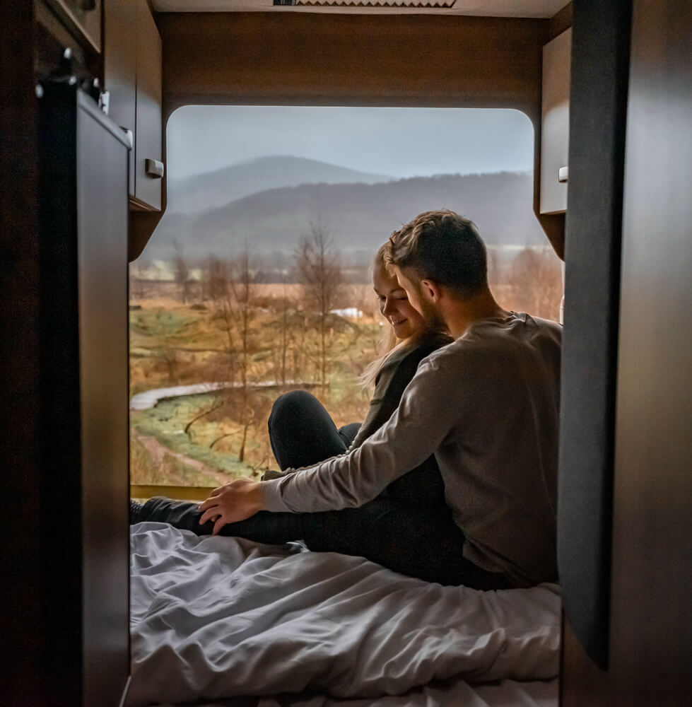 gemma and campbell admiring the view out of the campervan