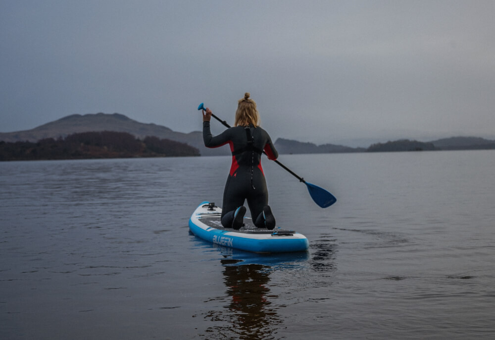 Gemma kneeling on a board on Loch Lomond
