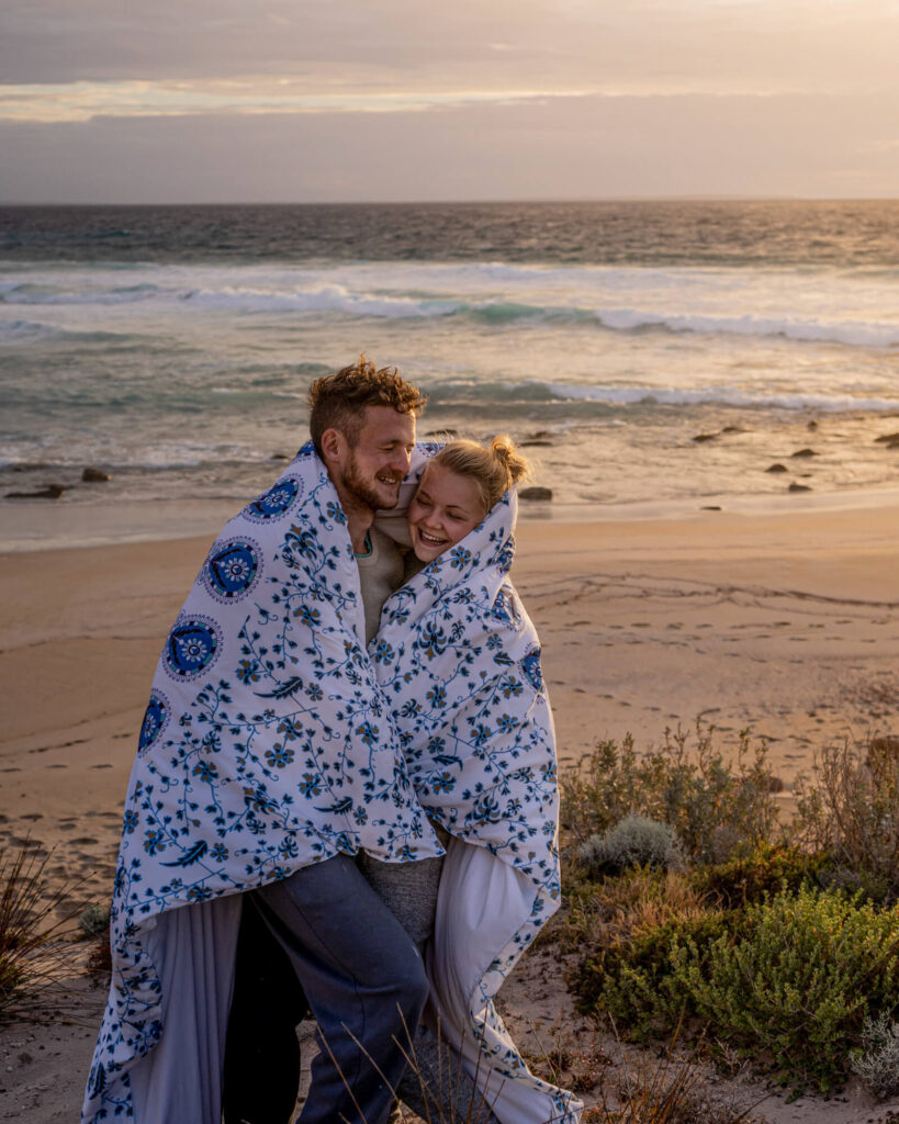 couple in duvet on beach