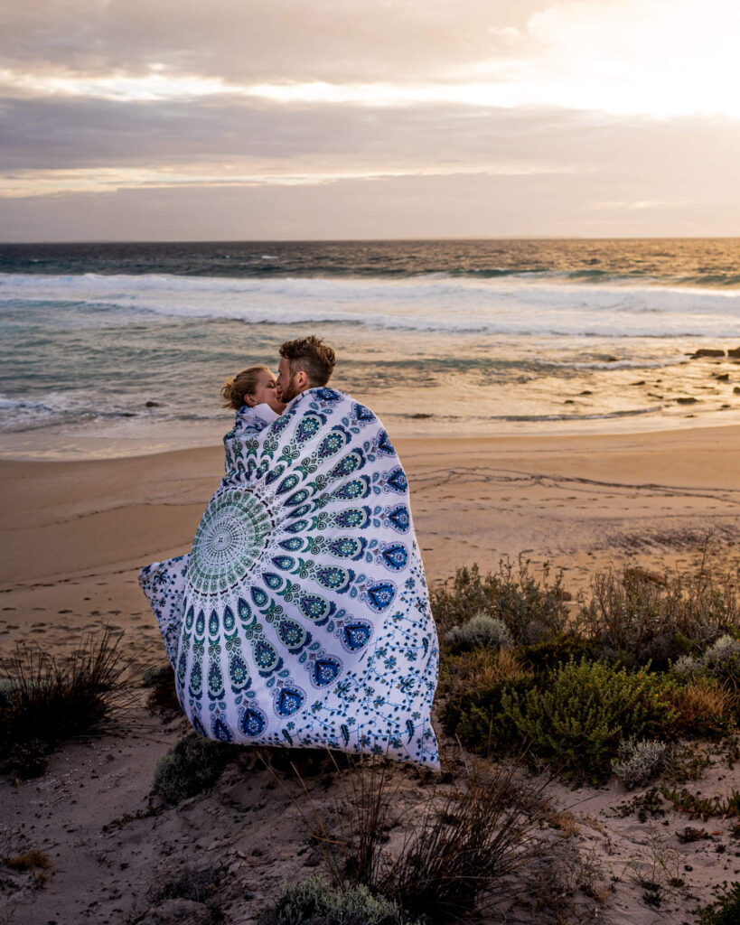 couple in duvet on beach sunset