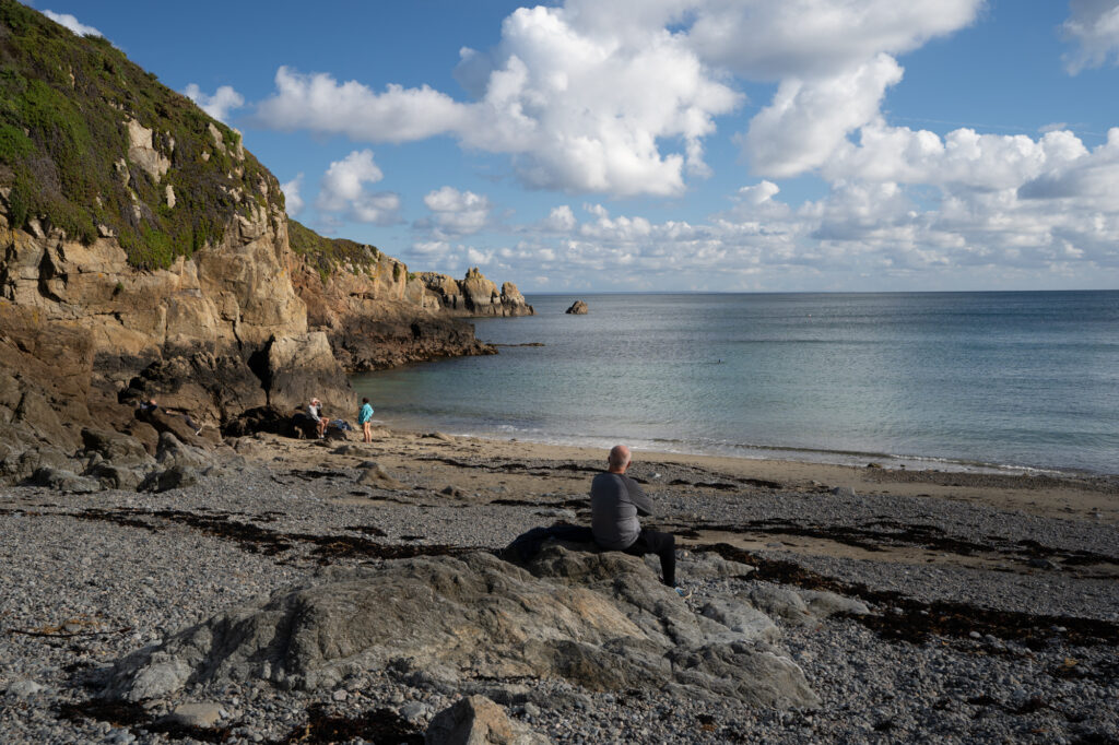 man sitting at Saints Bay Guernsey