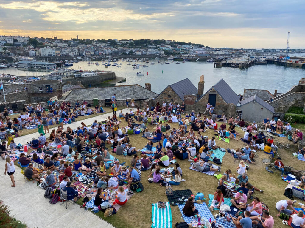 castle view over harbour and people sitting in grounds