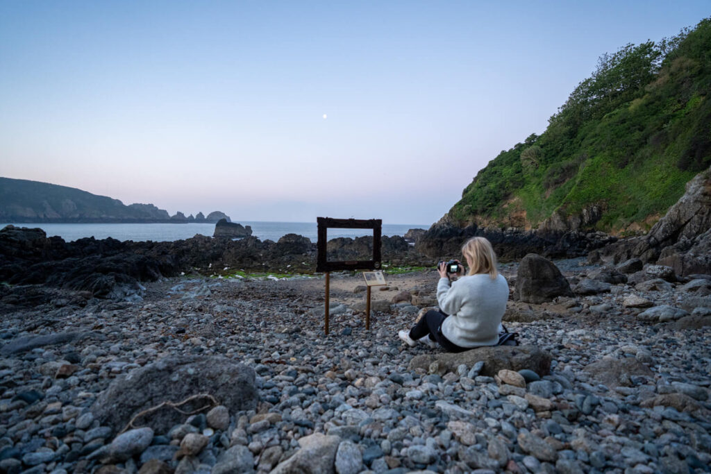 gemma sitting looking at metal frame on stoney beach