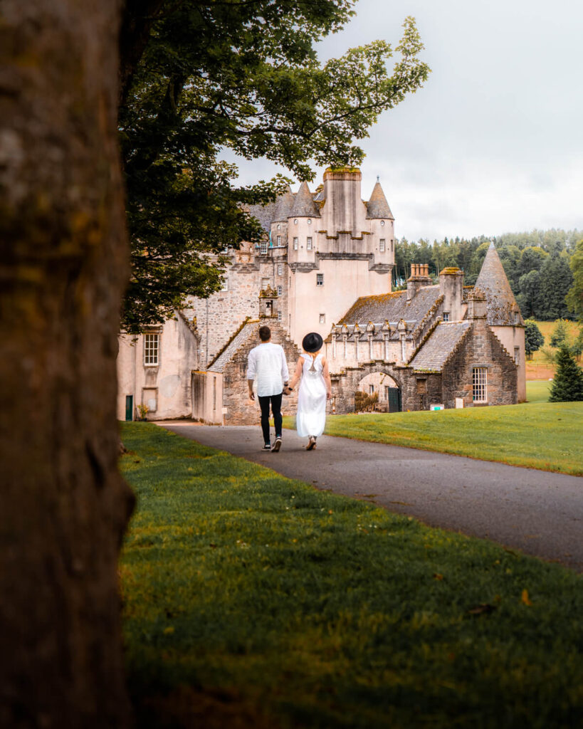 couple walking towards castle fraser scotland