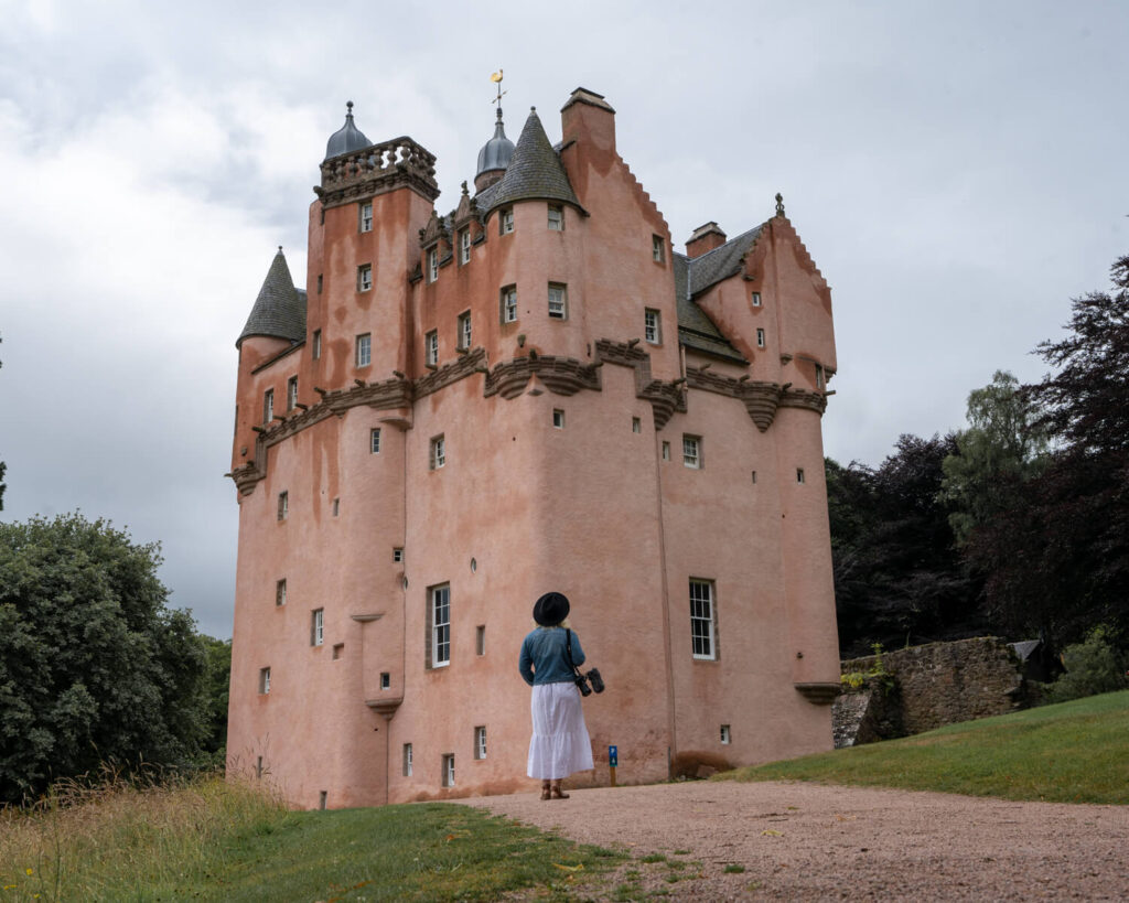 girl walking towards craigievar castle aberdeenshire