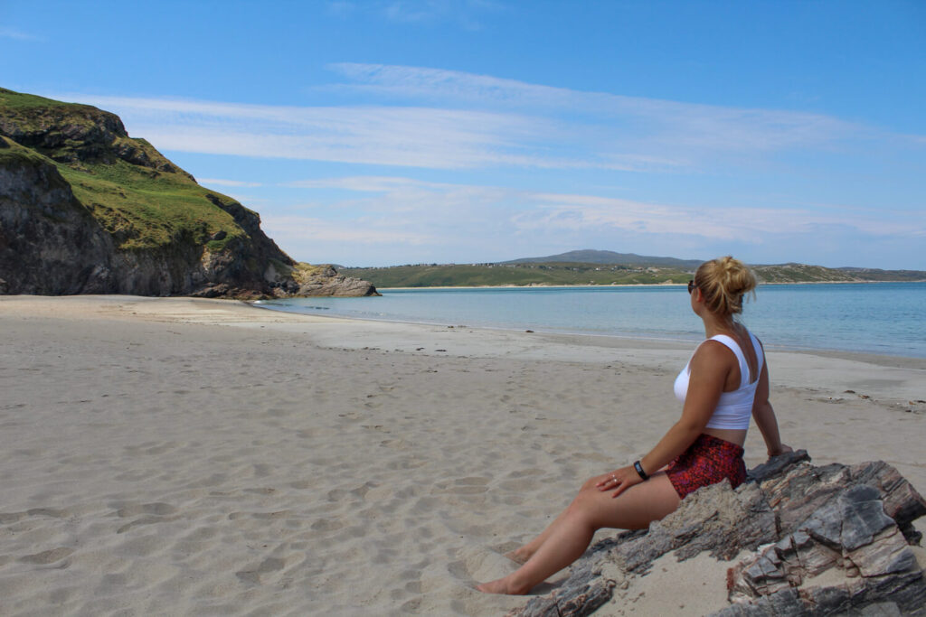 girl sitting on rock on beach