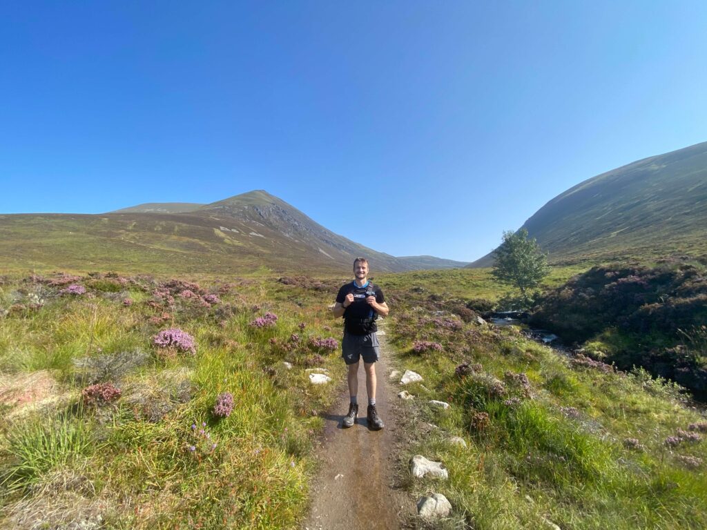 man standing in front of ben wyvis