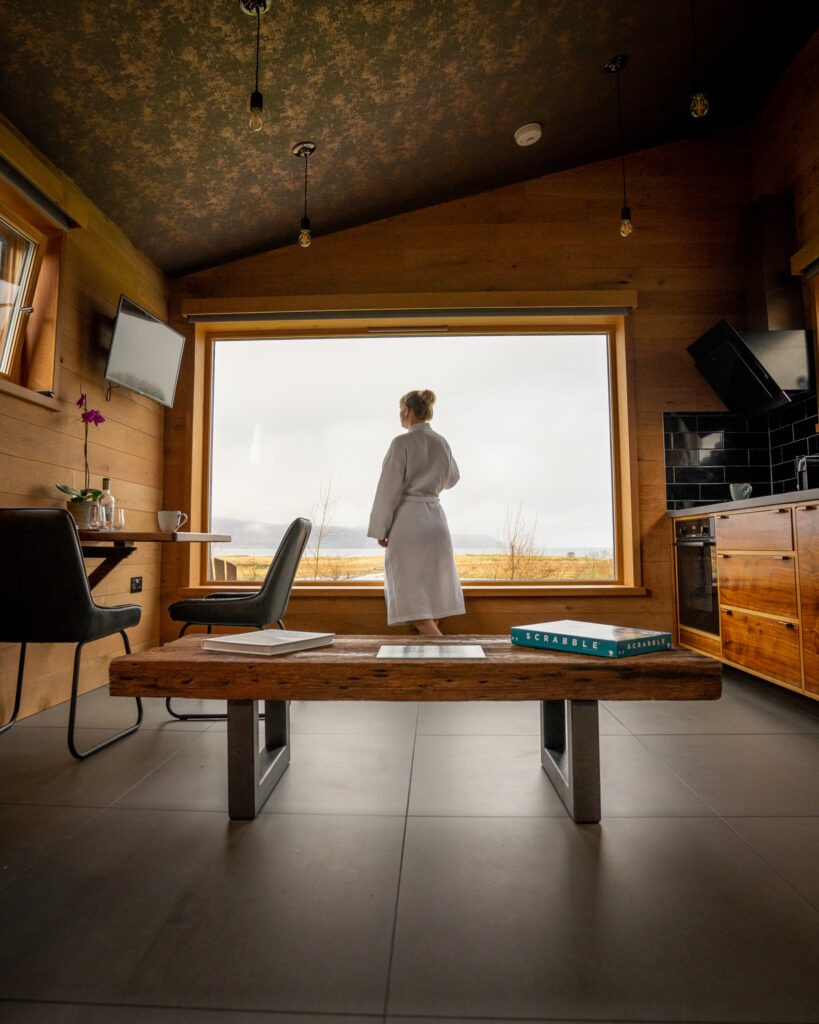 lady looking out window at view in white dressing gown