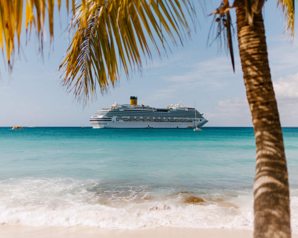 A cruise ship docked off a paradise Caribbean beach